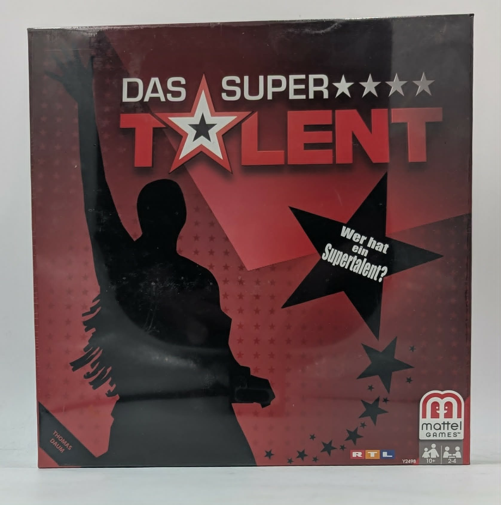 Das Supertalent Brettspiel Box in Rot und Schwarz mit der Silhouette einer Person und Sternen.