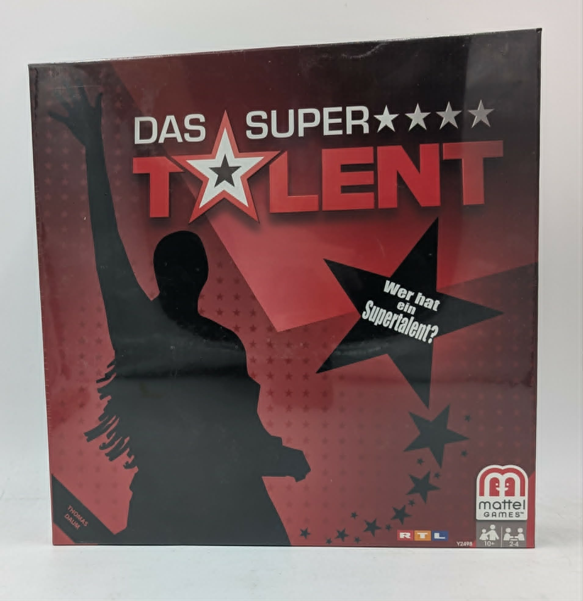 Das Supertalent Gesellschaftsspiel Schachtel mit rotem Hintergrund, Personensilhouette und Sternen.