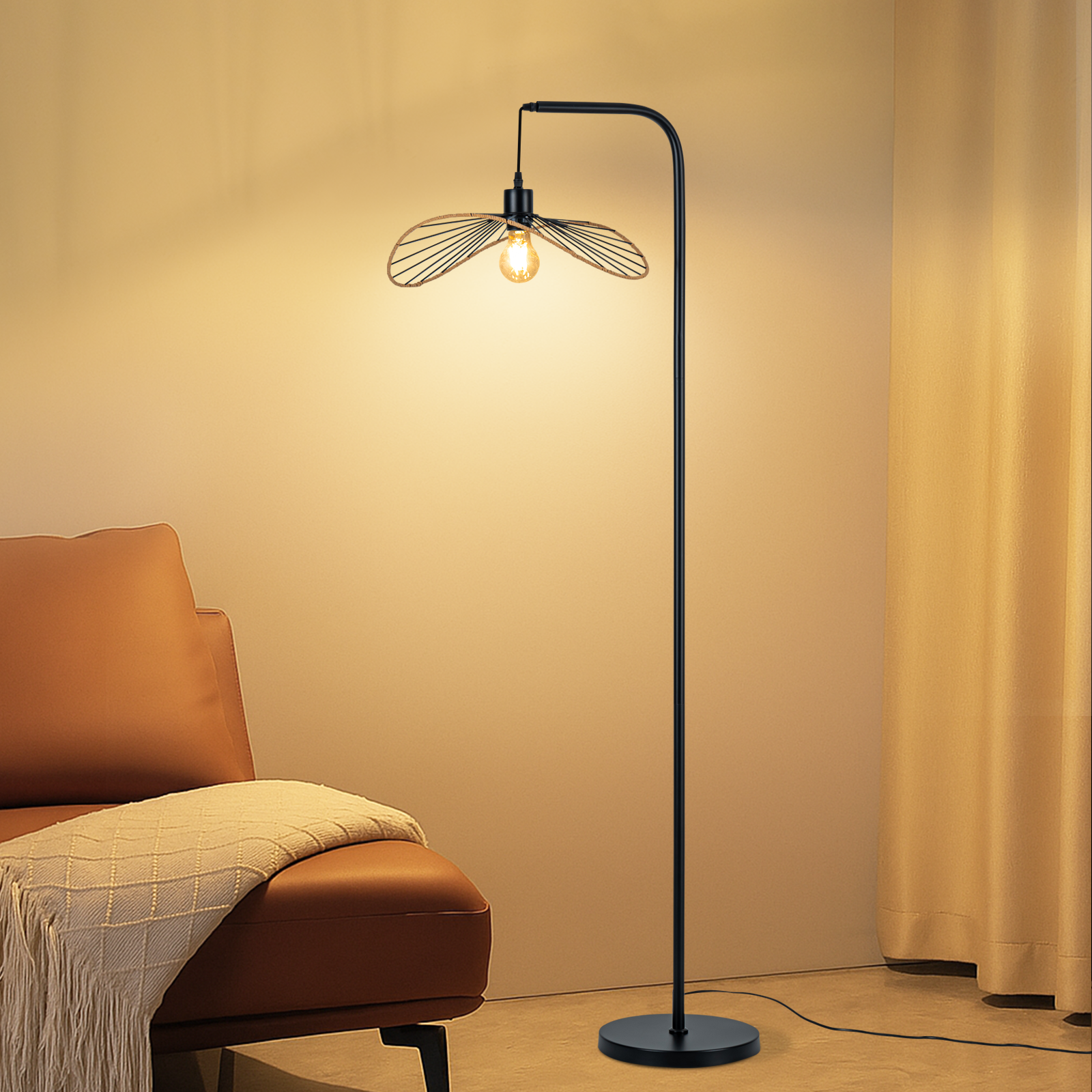Una lámpara de pie negra junto a un sillón de cuero marrón con una manta clara, ante una pared beis y cortinas.