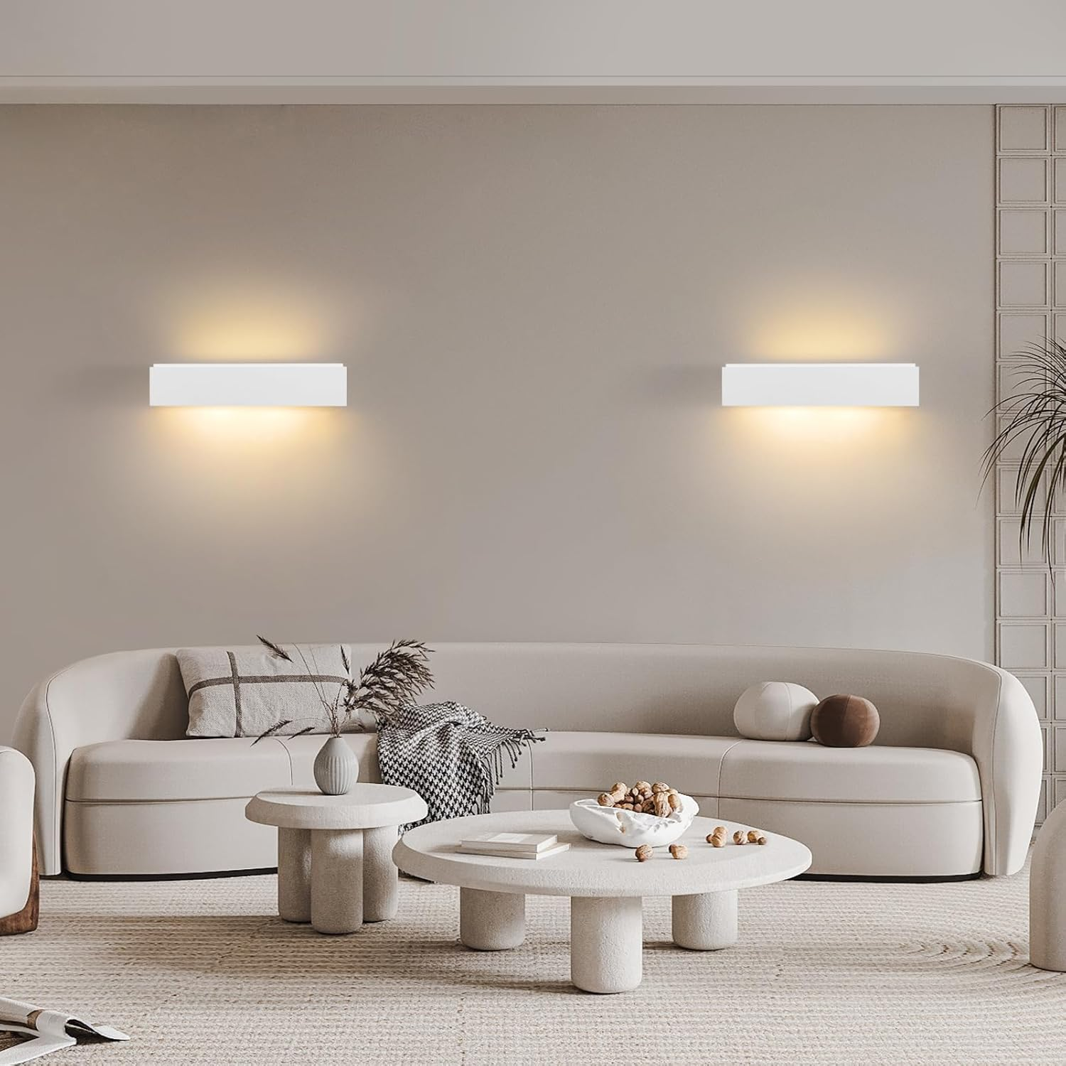 Un salón minimalista con sofá claro, mesas de centro redondas y apliques.