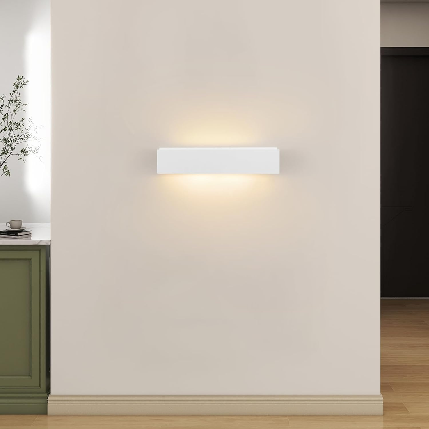 Un aplique de pared blanco moderno cuelga de una pared clara, proyectando un brillo cálido hacia arriba y hacia abajo.