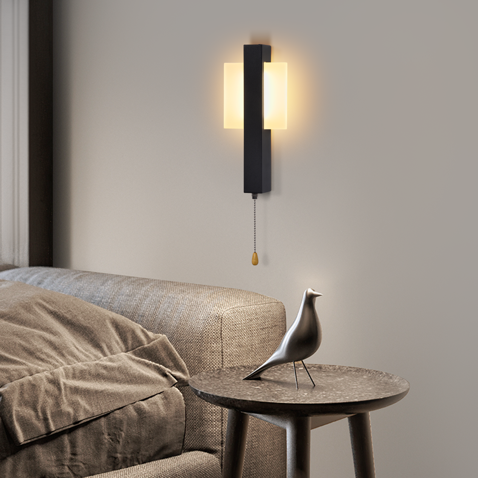 Un aplique de pared negro con pantallas de vidrio iluminadas y una pequeña figura de pájaro en una mesa auxiliar.