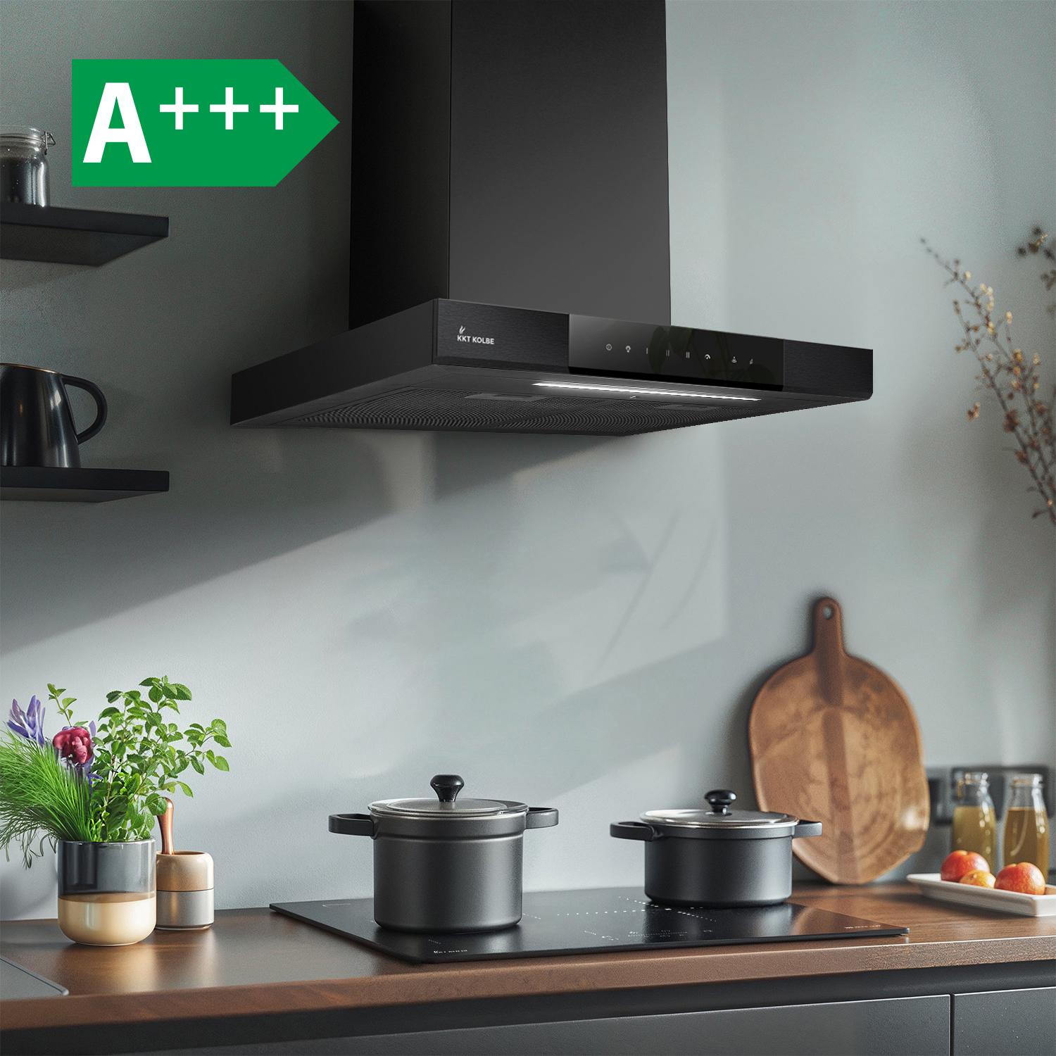 Moderna cappa aspirante nera sopra un piano cottura in una cucina con piano di lavoro in legno e piante.
