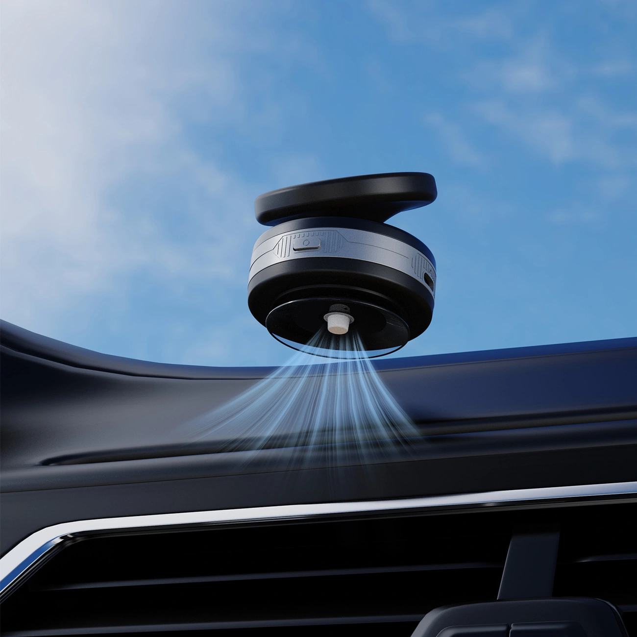 Un deodorante nero e rotondo spruzza nebbia blu sul cruscotto di un'auto, con sfondo di cielo azzurro.