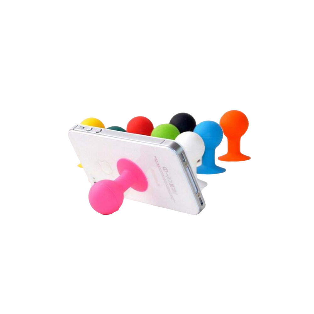Uno smartphone bianco poggia su un supporto a ventosa rosa, con altri supporti colorati dietro.