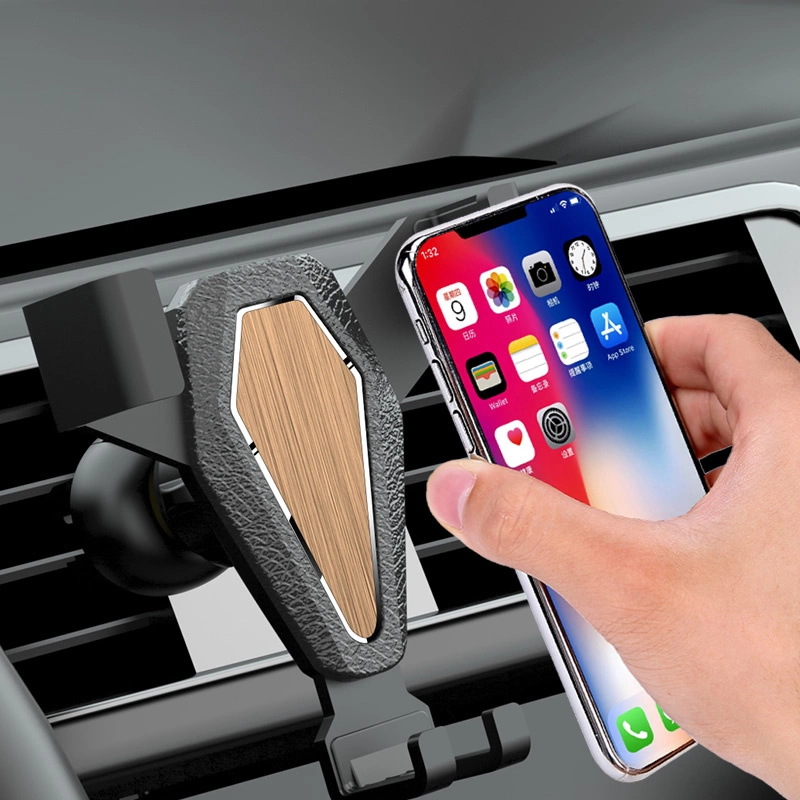 Una mano posiziona uno smartphone in un supporto per auto con inserti in legno sulla bocchetta dell'aria.