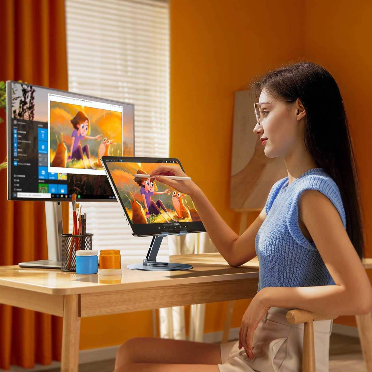 Una donna disegna con un pennino su un tablet posizionato su una scrivania in una stanza arancione.