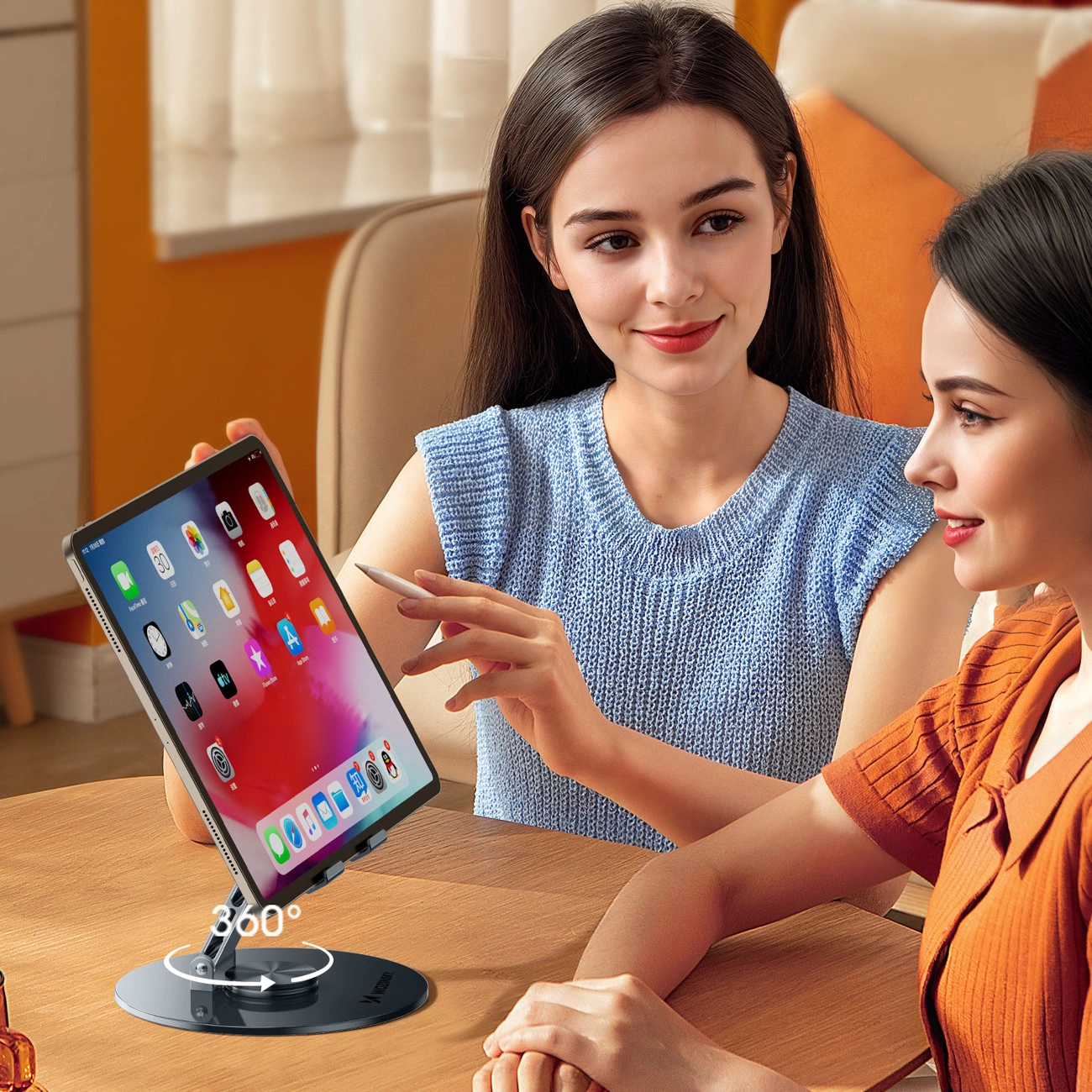 Due donne guardano un tablet su un supporto girevole a 360 gradi, una indica lo schermo con un pennino.