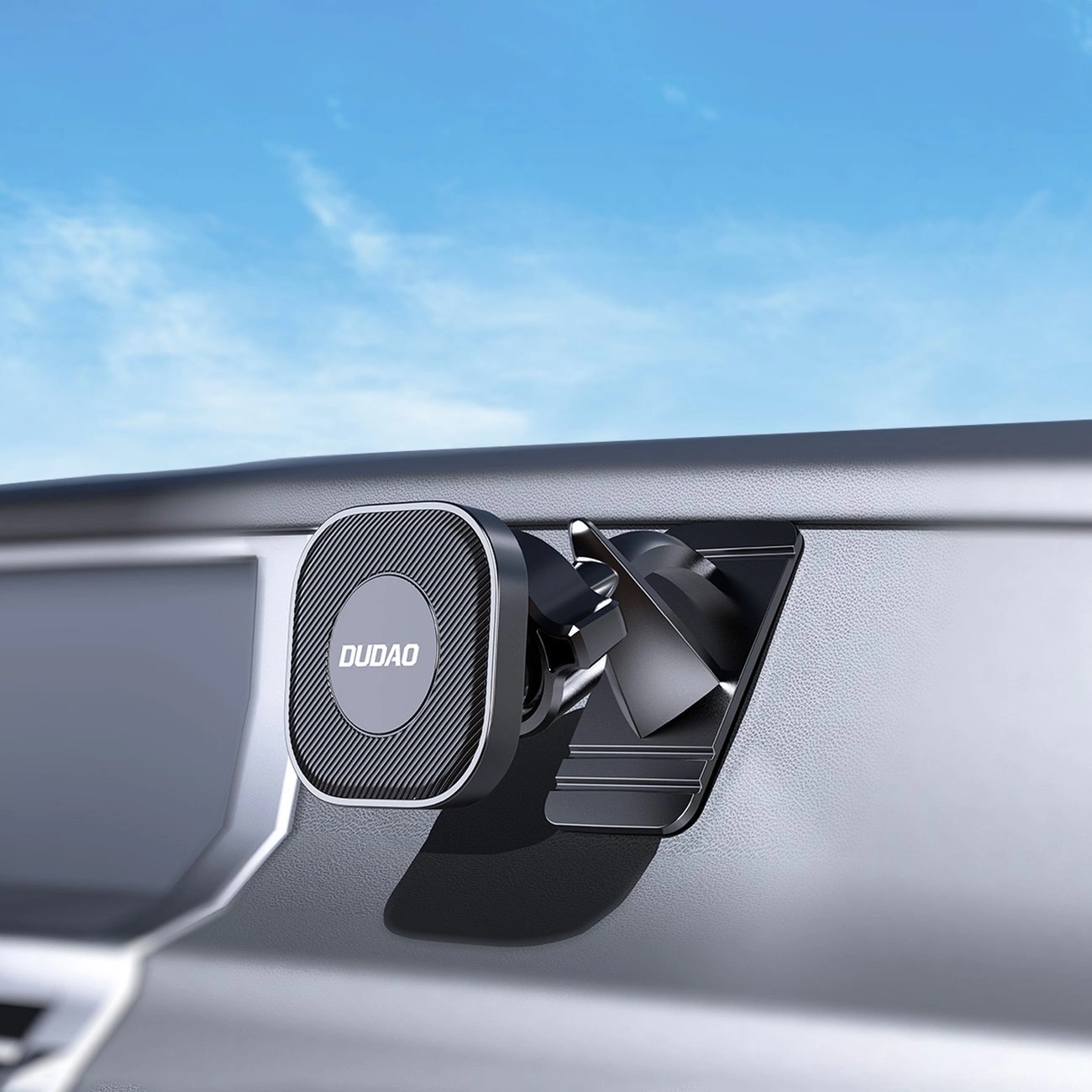 Un supporto per telefono Dudao nero è montato sul cruscotto dell'auto, con cielo azzurro.