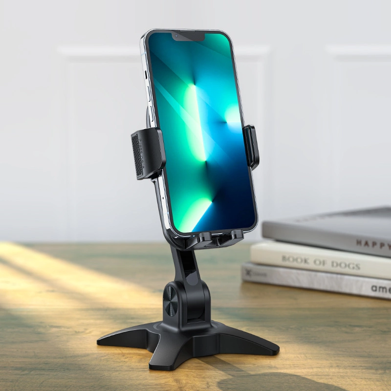 Uno smartphone è su un supporto a treppiede nero su un tavolo di legno, con libri sullo sfondo.