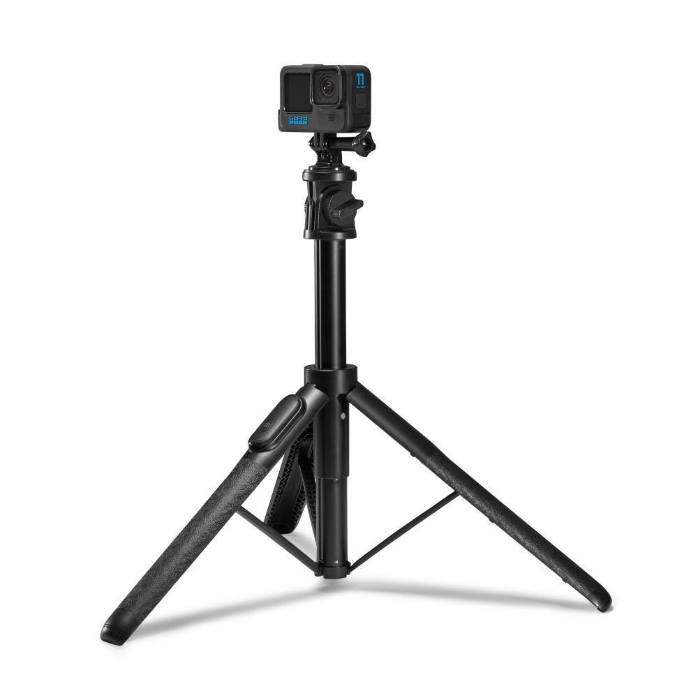 Una action camera nera è montata su un treppiede regolabile con tre gambe su sfondo bianco.