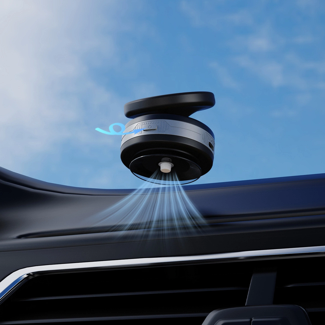 Un deodorante per auto nero spruzza una nebbia fine sul cruscotto con cielo azzurro.