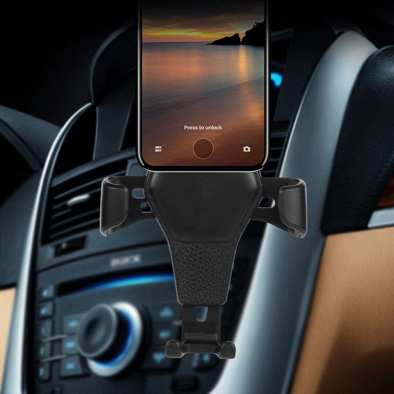 Uno smartphone nero montato su un supporto per bocchetta dell'aria con sfondo tramonto.