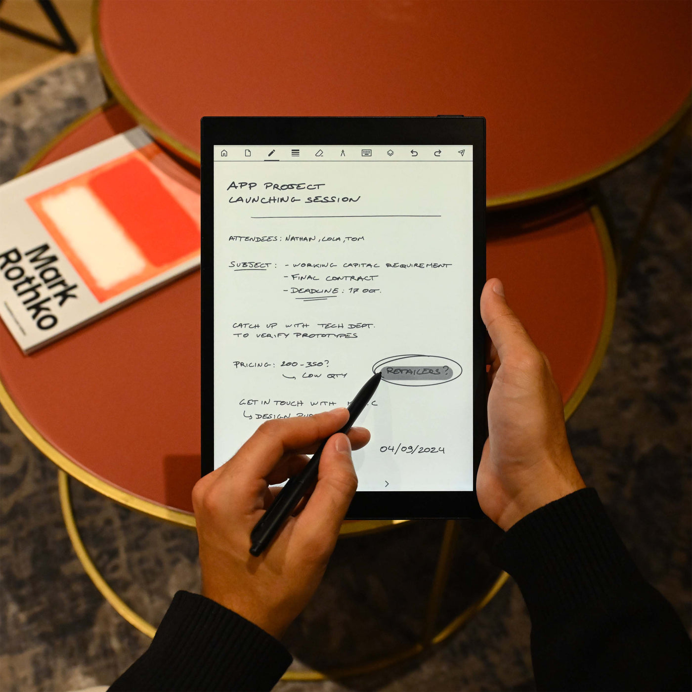 Persona sosteniendo un bloc digital, escribiendo notas con un lápiz óptico.