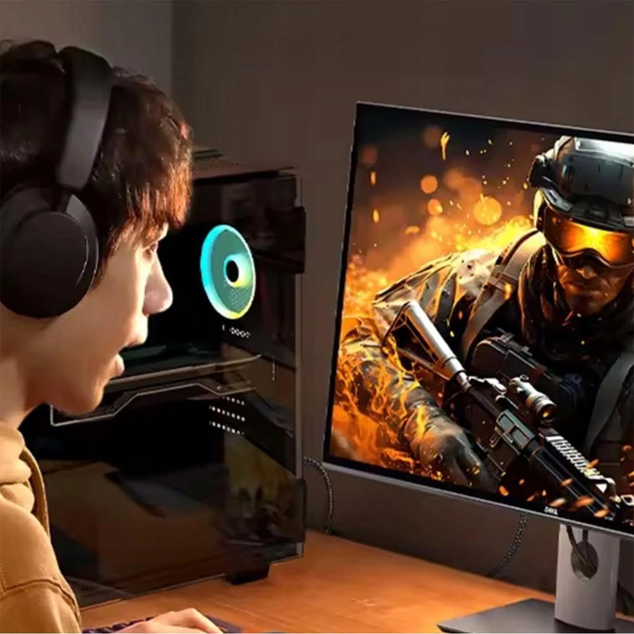 Un ragazzo con le cuffie gioca a un videogioco d'azione su un monitor, con scene di combattimento di fuoco.