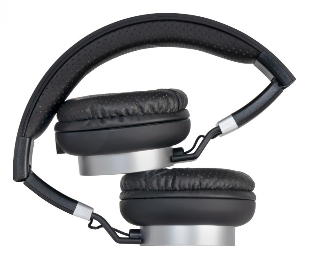 Un par de auriculares supraurales negros y plateados, doblados ordenadamente sobre fondo blanco.