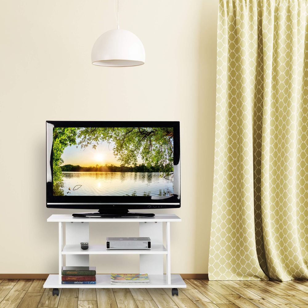 Ein Fernseher auf einem weißen Ständer mit Landschaft, darüber eine weiße Lampe und gemusterte Vorhänge.