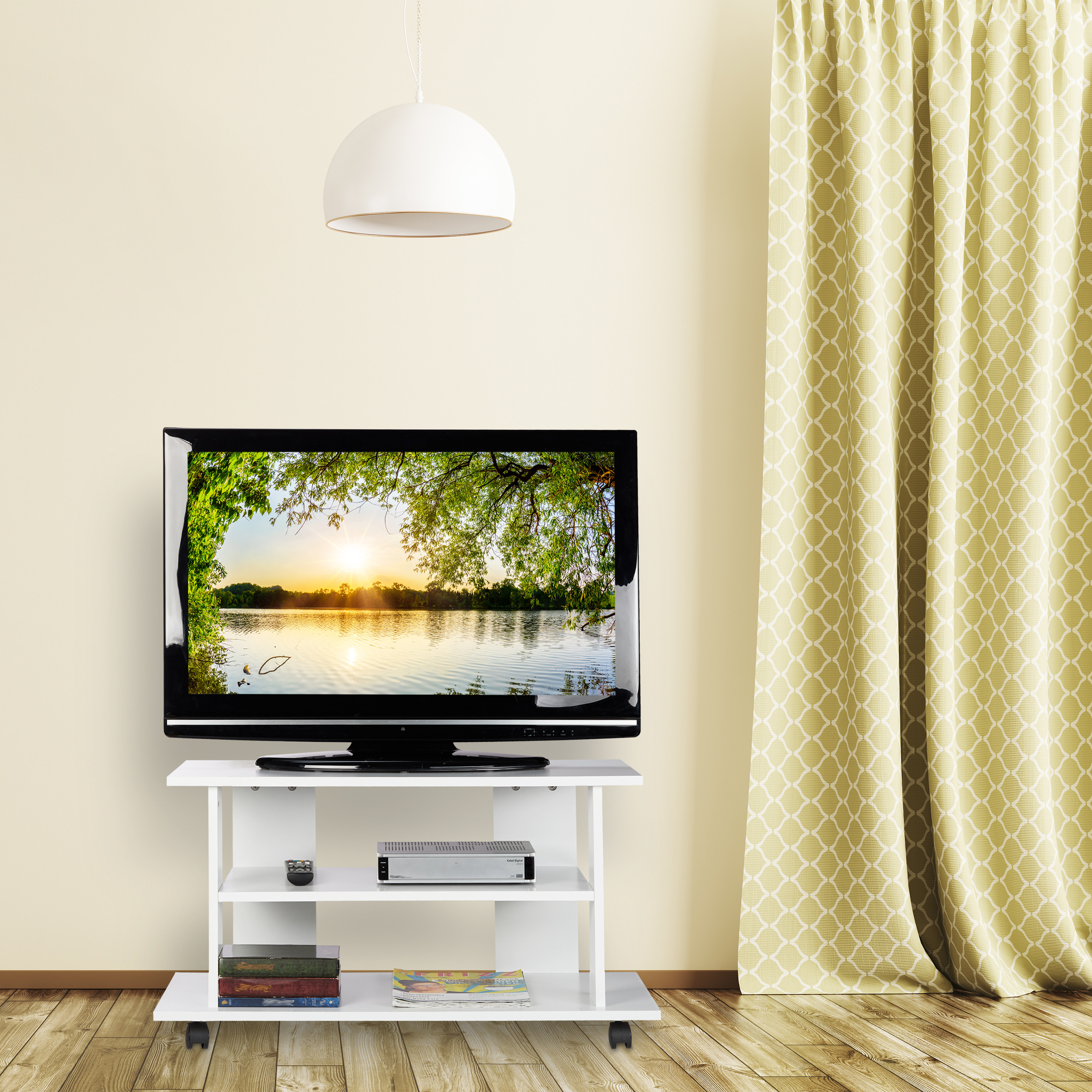 Ein Fernseher auf einem weißen Stand vor einer hellen Wand mit einer gemusterten gelben Vorhang.