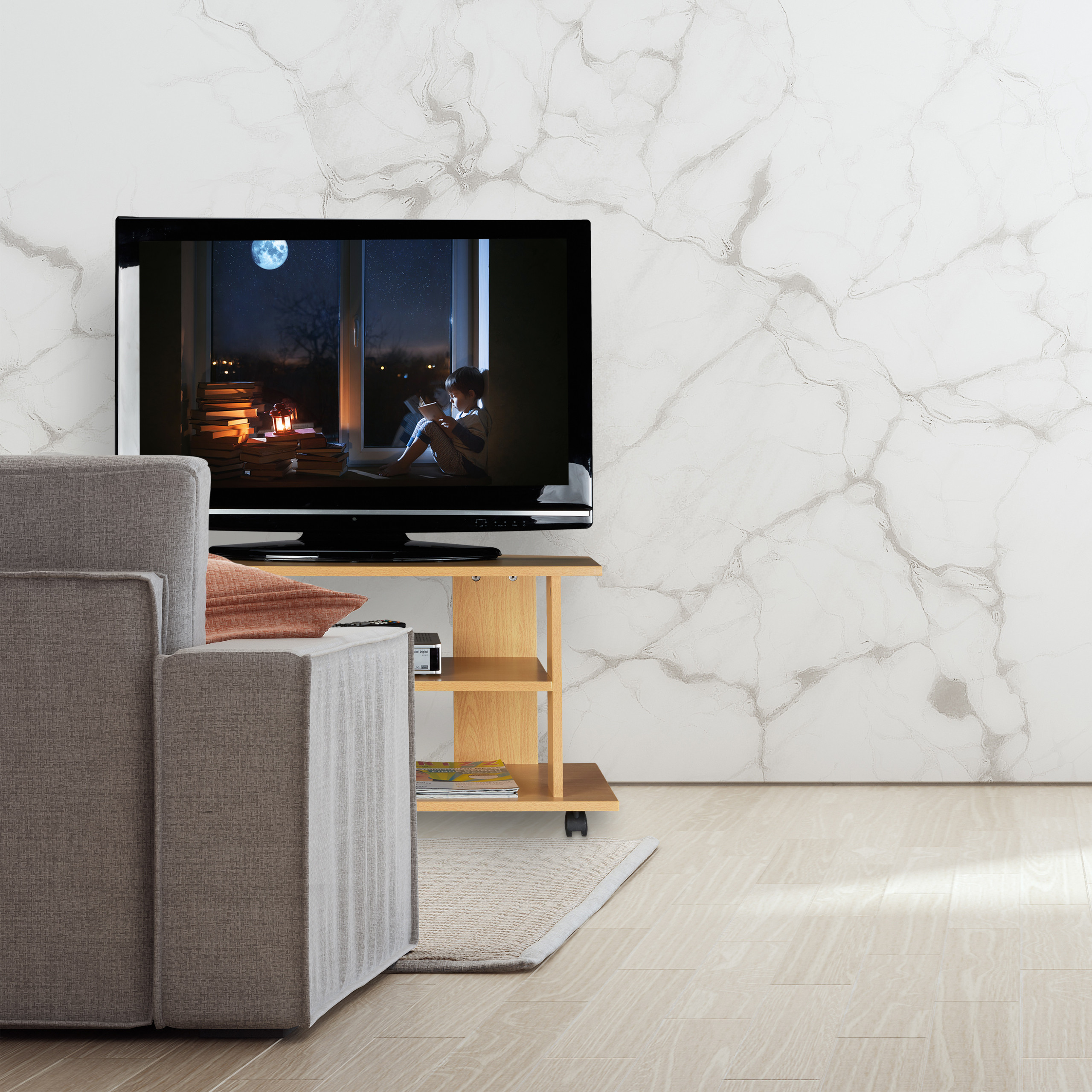 Ein Wohnzimmer mit einem grauen Sofa, einem TV mit lesendem Kind und einer weißen Marmorwand.