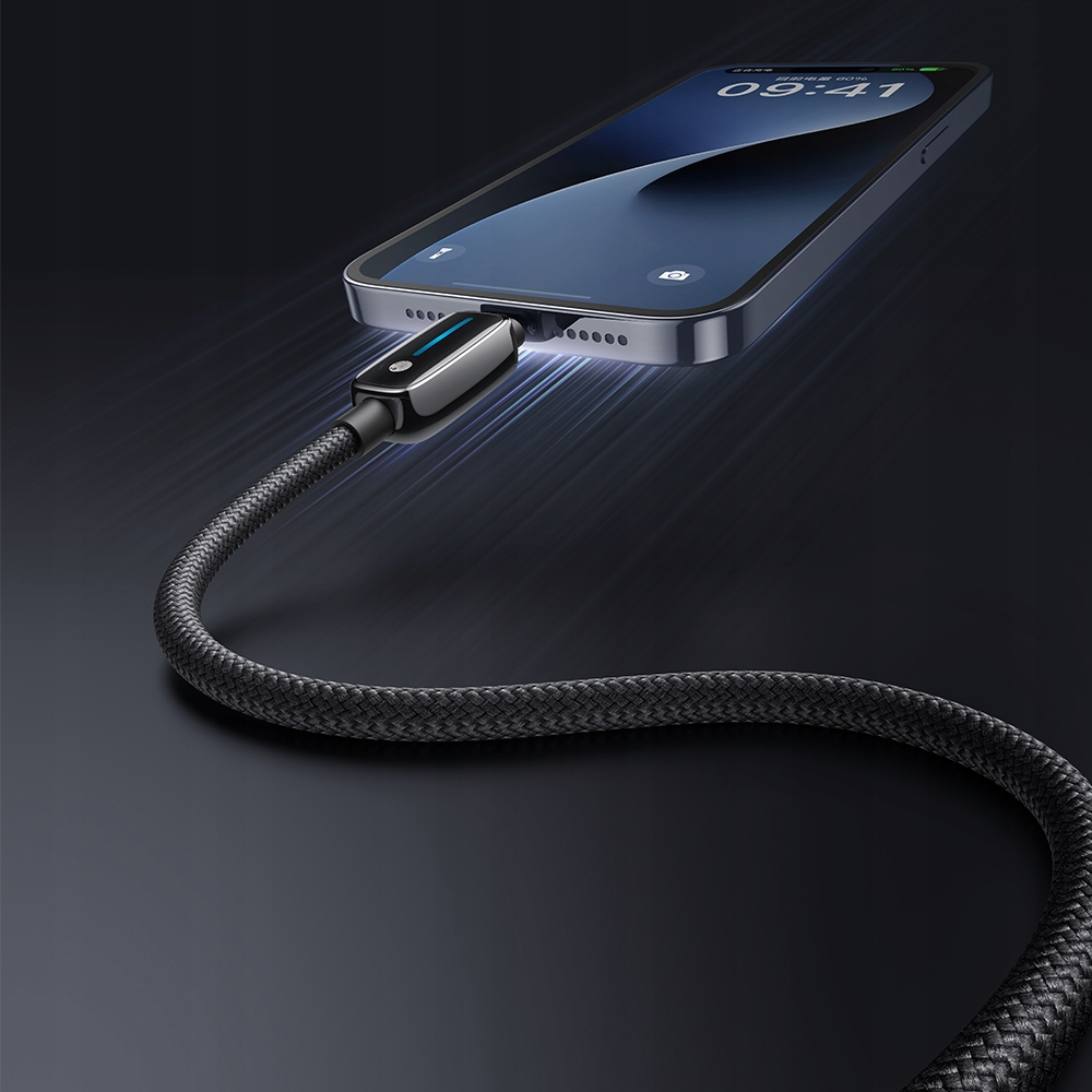Un cavo di ricarica intrecciato nero è collegato a uno smartphone su uno sfondo scuro.