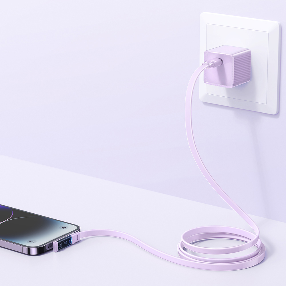 Un caricabatterie viola inserito nella presa, collegato a uno smartphone su una superficie bianca.