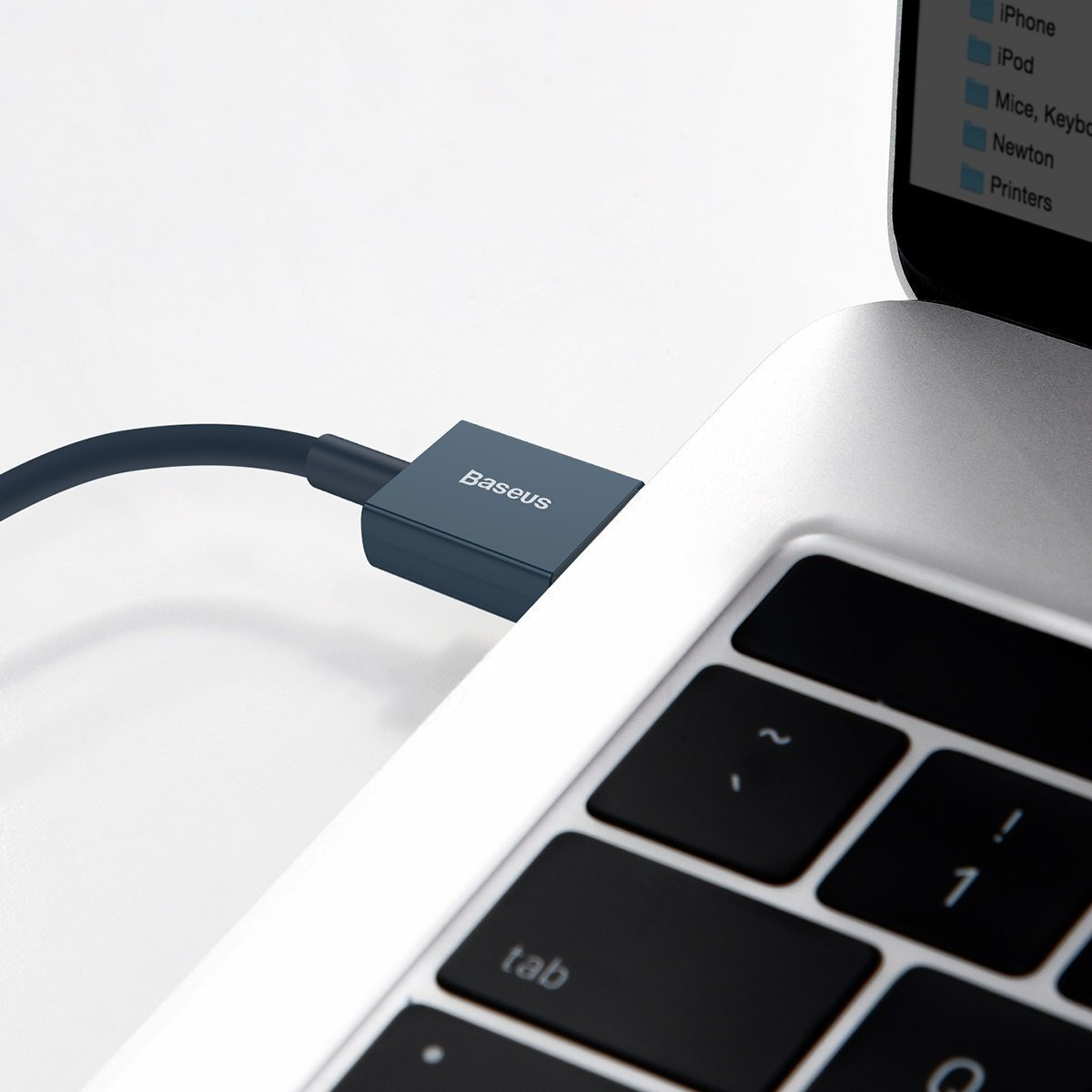 Un cavo blu scuro a marchio Baseus è collegato al lato di un computer portatile argentato.