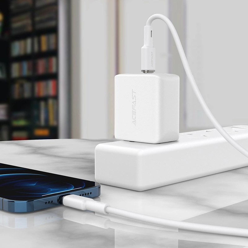 Un caricabatterie da muro bianco Acefast collegato a una ciabatta con un cavo connesso a uno smartphone.