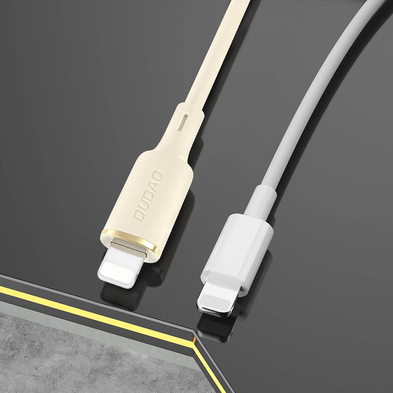 Due cavi di ricarica Lightning beige e bianco su una superficie scura.