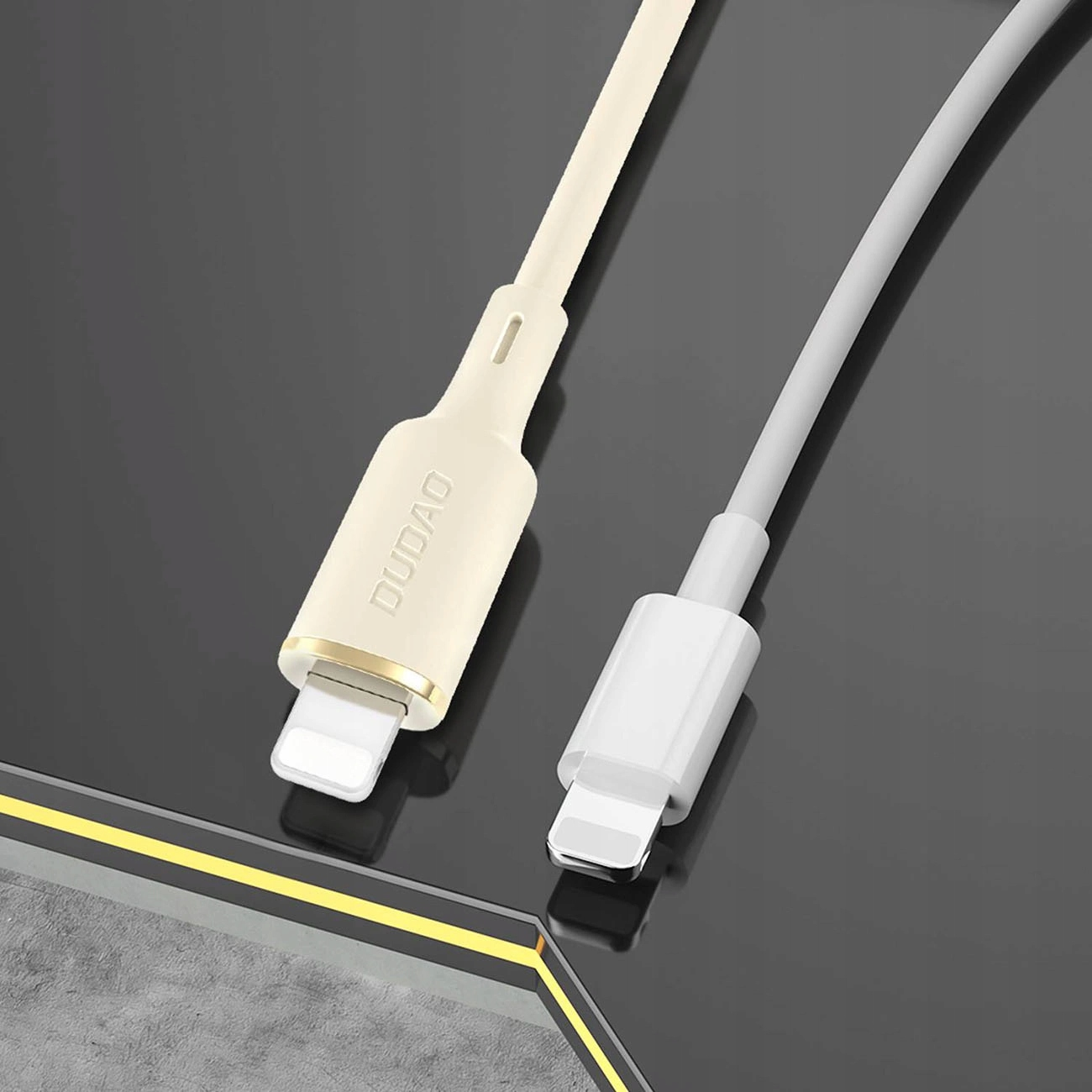 Due cavi Lightning su superficie scura, uno beige con marchio DUDAO e l'altro bianco.