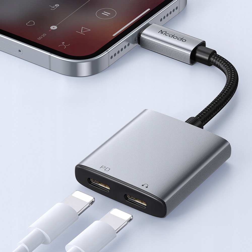 Un adattatore Mcdodo argento è collegato a uno smartphone, con due cavi bianchi inseriti sotto.