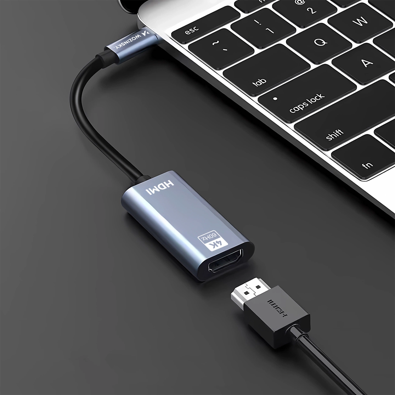 Un adattatore grigio da USB-C a HDMI collegato a un computer portatile.