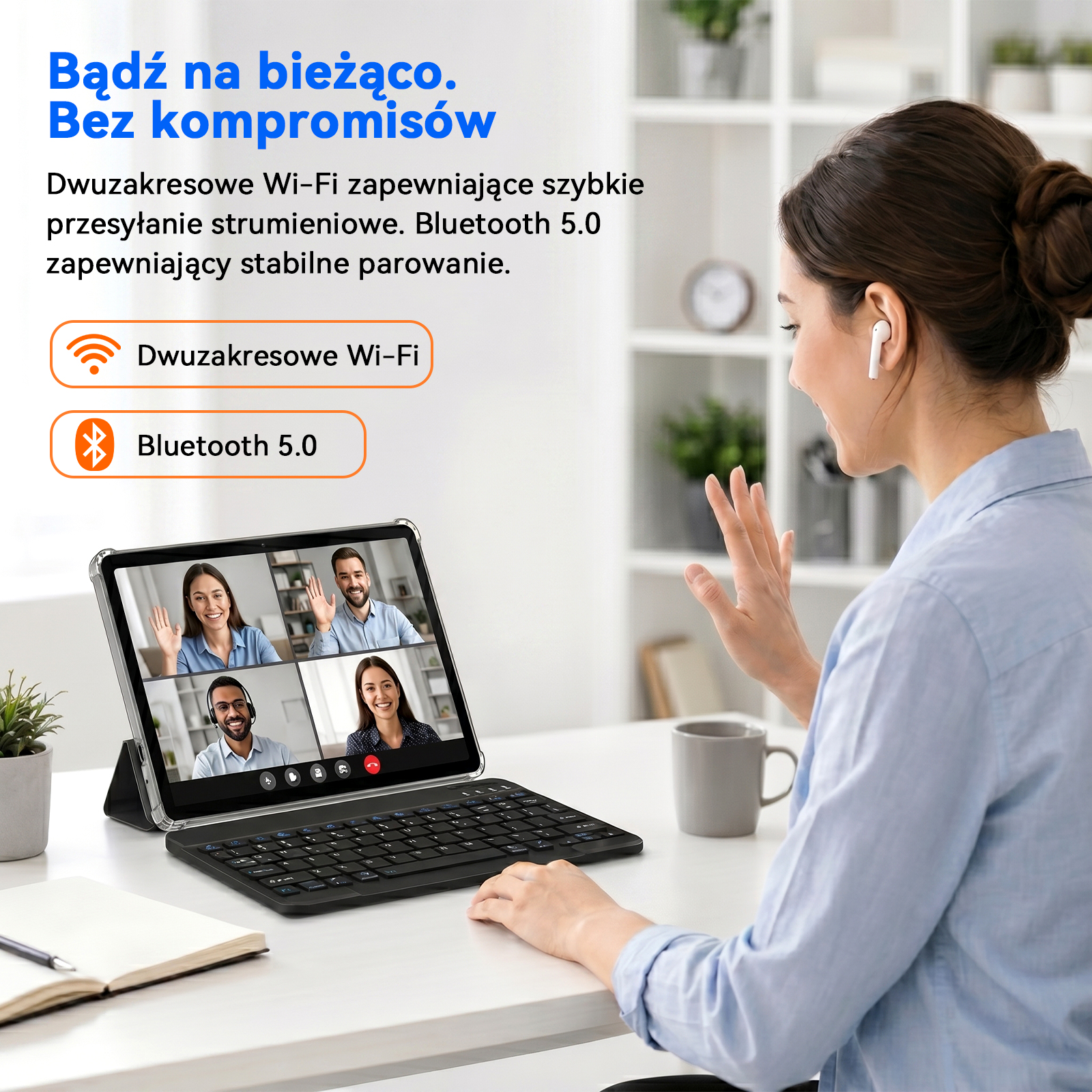 Kobieta machająca podczas wideorozmowy na tablecie z klawiaturą, siedząc przy biurku z kubkiem i notesem.