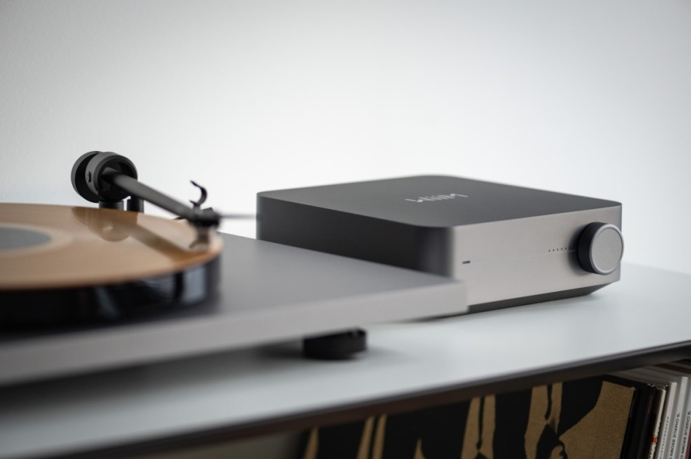 Czarny gramofon ze złotą płytą winylową i pasujące szare urządzenie audio.