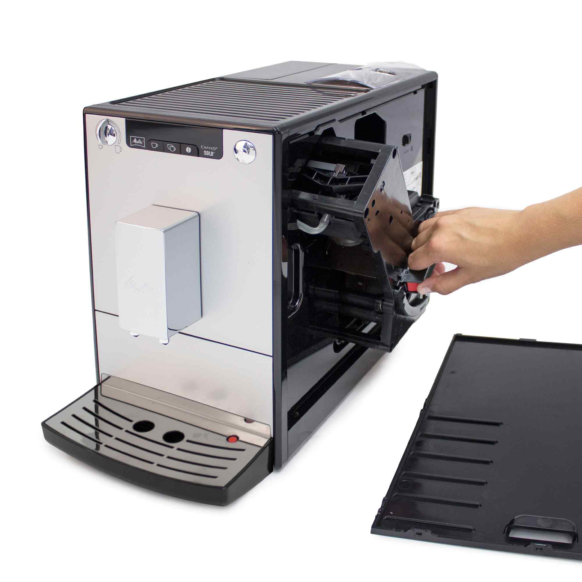 Una mano estrae l'unità erogatrice da una macchina da caffè nera e argentata.