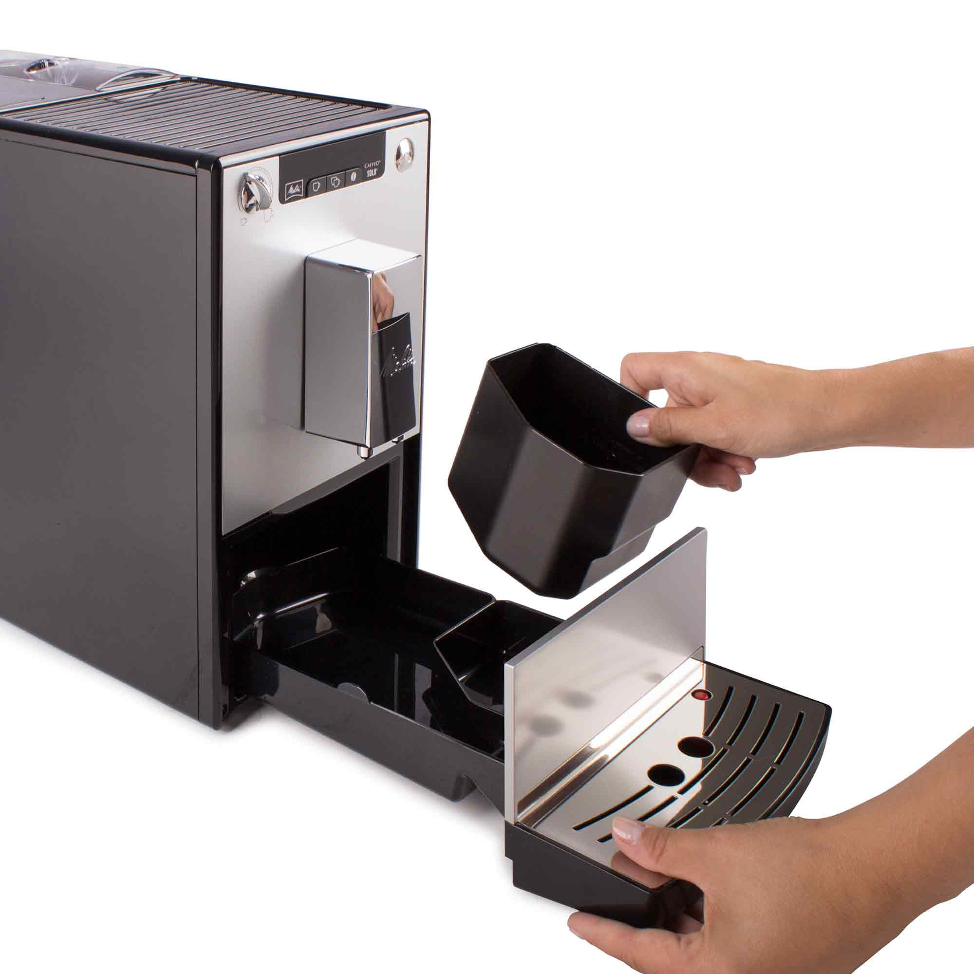 Persona che rimuove il vassoio raccogligocce da una moderna macchina da caffè.