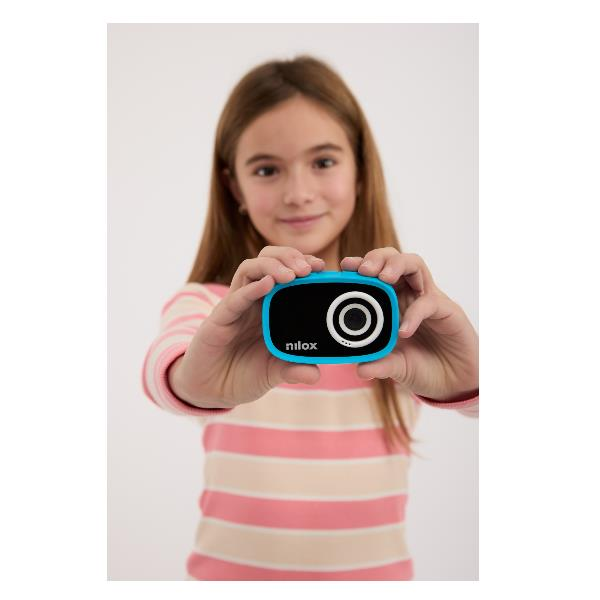 Una giovane ragazza con un maglione a righe mostra una fotocamera per bambini Nilox blu e nera.