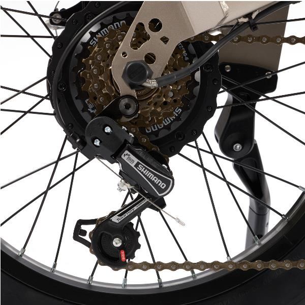 Nahaufnahme des Hinterrads eines Fahrrads mit Shimano Tourney Schaltwerk, Zahnkränzen und Kette vor weißem Hintergrund.