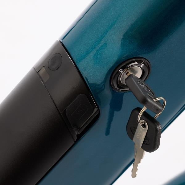Una llave insertada en la cerradura de un cuadro de e-bike turquesa brillante junto a un elemento negro.