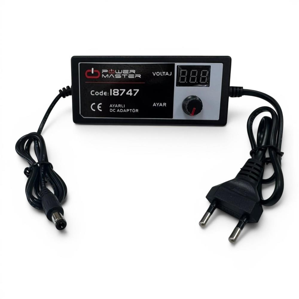 Beyaz zemin üzerinde dijital ekranlı, ayar düğmeli ve iki kablolu Power Master DC adaptör.