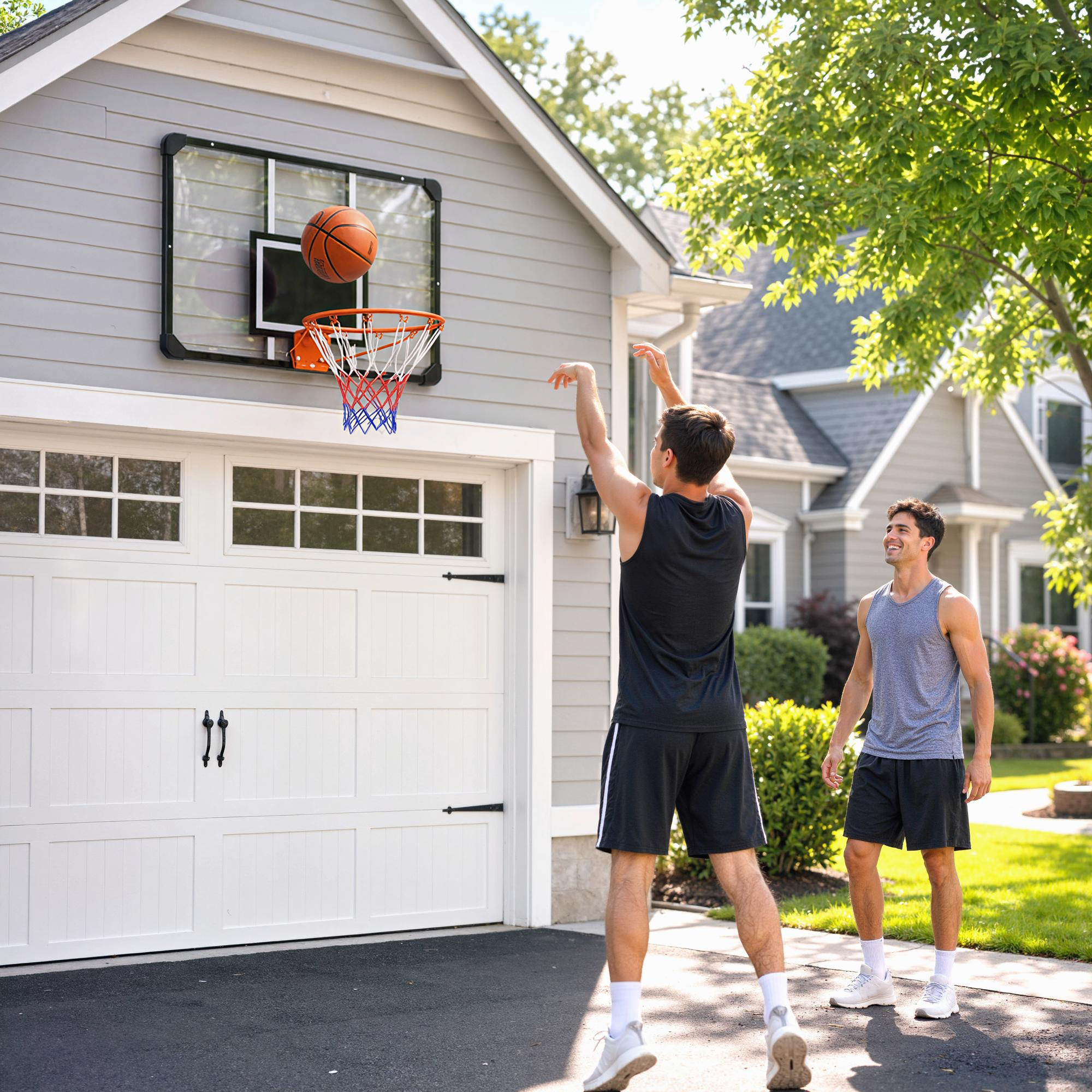 Dos hombres juegan al baloncesto en un camino de entrada, uno lanza un balón hacia una canasta en el garaje.