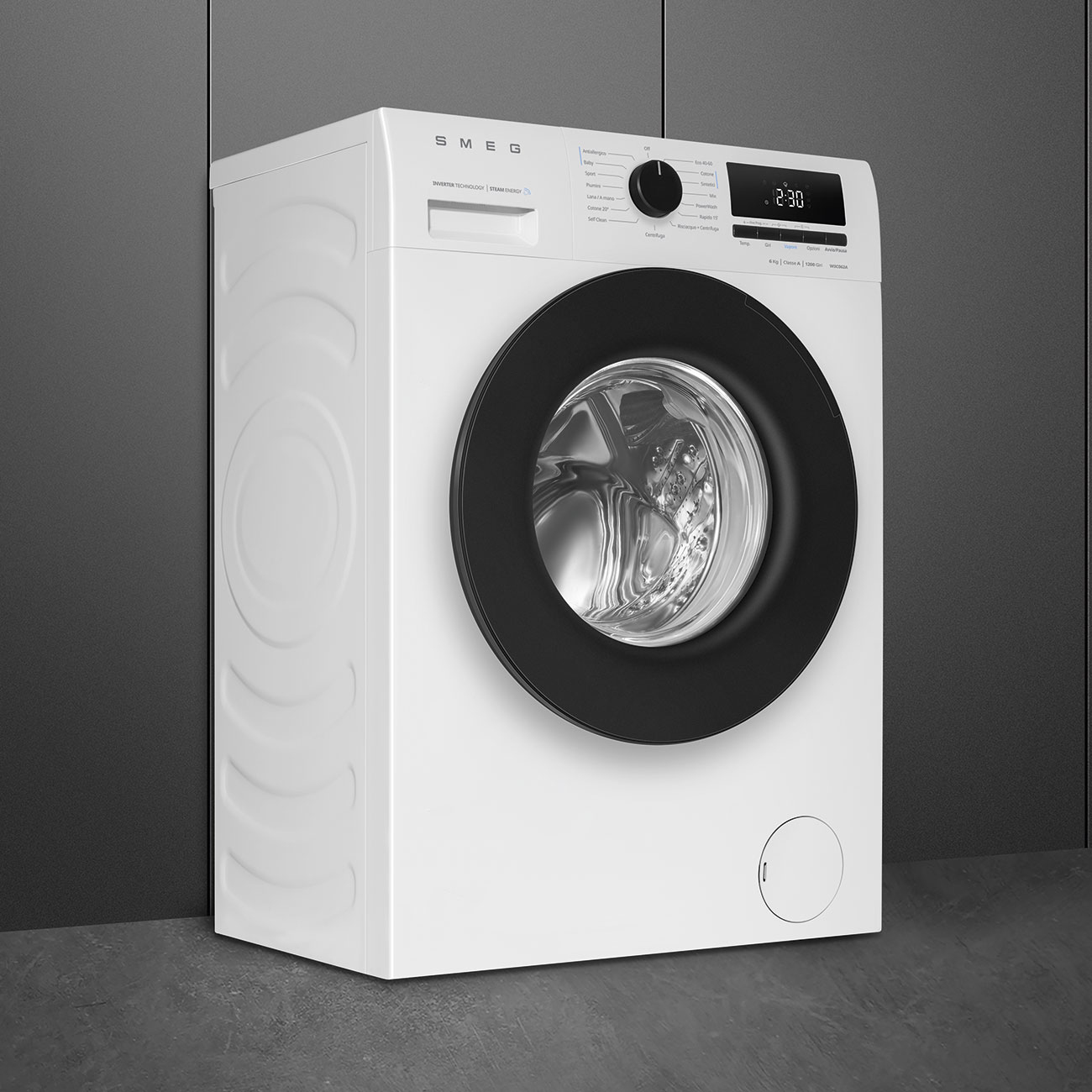 Una lavatrice bianca Smeg con oblò nero e display digitale si trova davanti a una parete grigia.