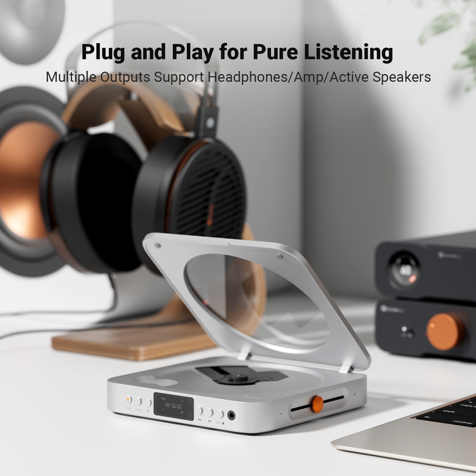 A silver CD player on a desk with headphones in the background.