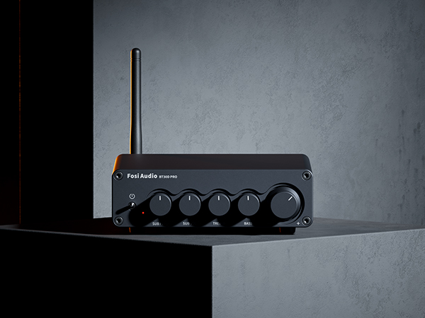 Ein schwarzer Fosi Audio Verstärker mit Antenne und Reglern steht auf einem grauen Block.