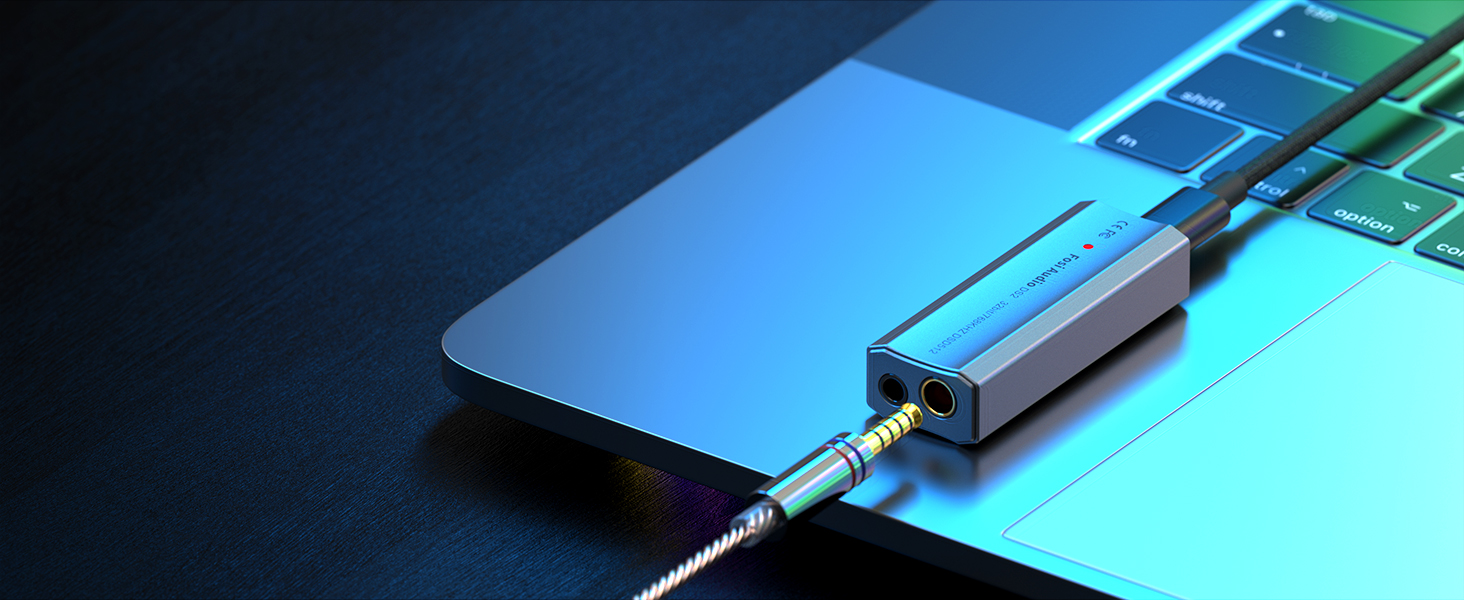 Un convertitore audio argento con jack per cuffie e cavo su un computer portatile.