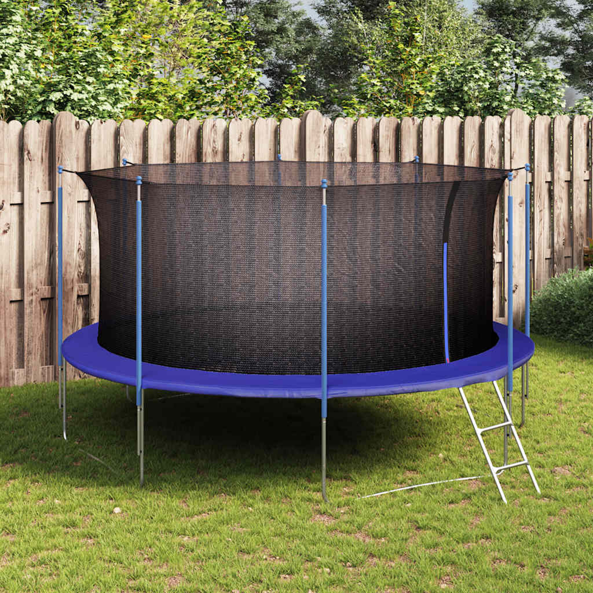 Un trampolino blu con rete di sicurezza si trova su un prato davanti a una staccionata.