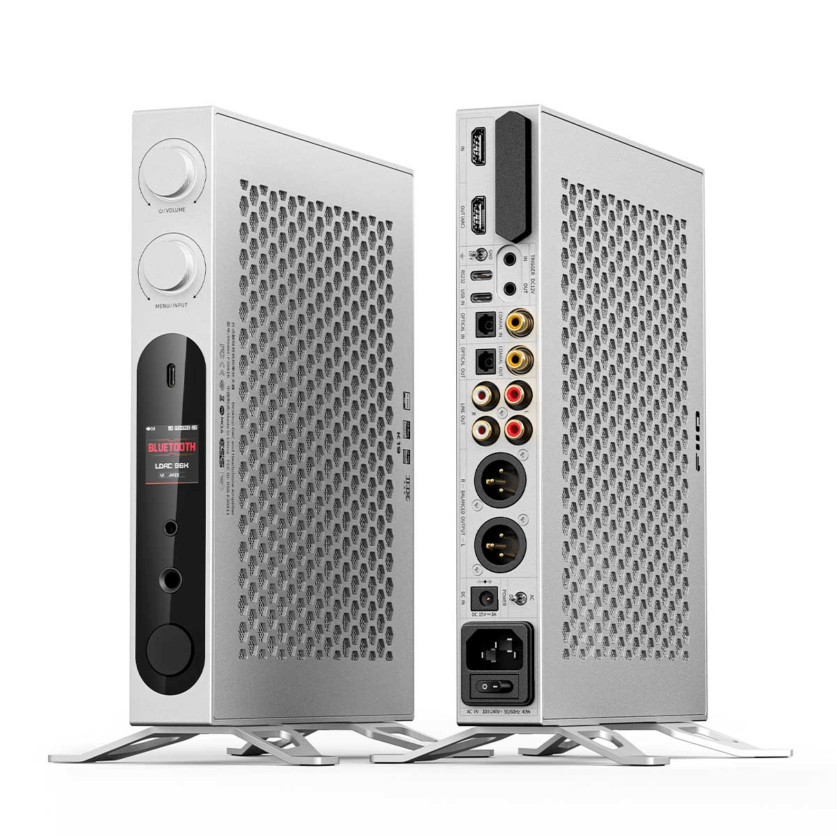 Dos vistas de un amplificador de alta fidelidad de metal plateado con perillas de control, pantalla y varios puertos.