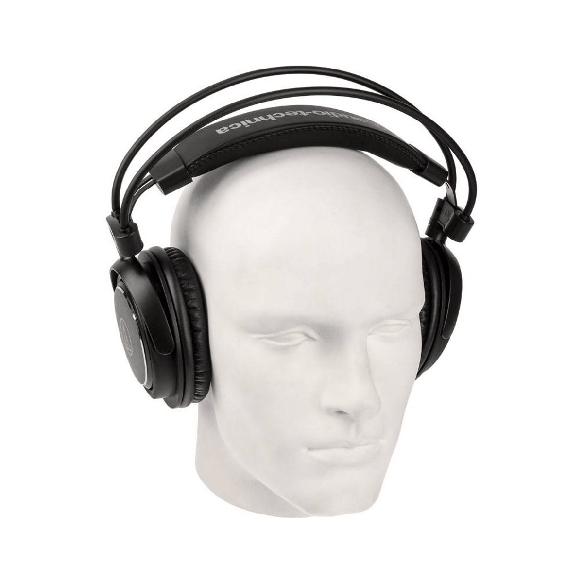 Cuffie over-ear nere su una testa di manichino bianca su sfondo bianco.