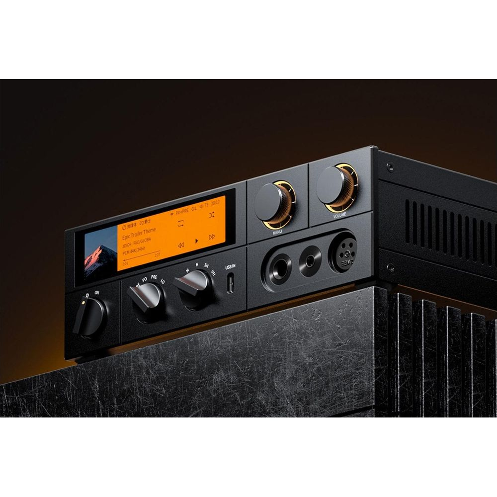 Dispositivo de audio negro con pantalla, perillas y diales en una superficie texturizada.