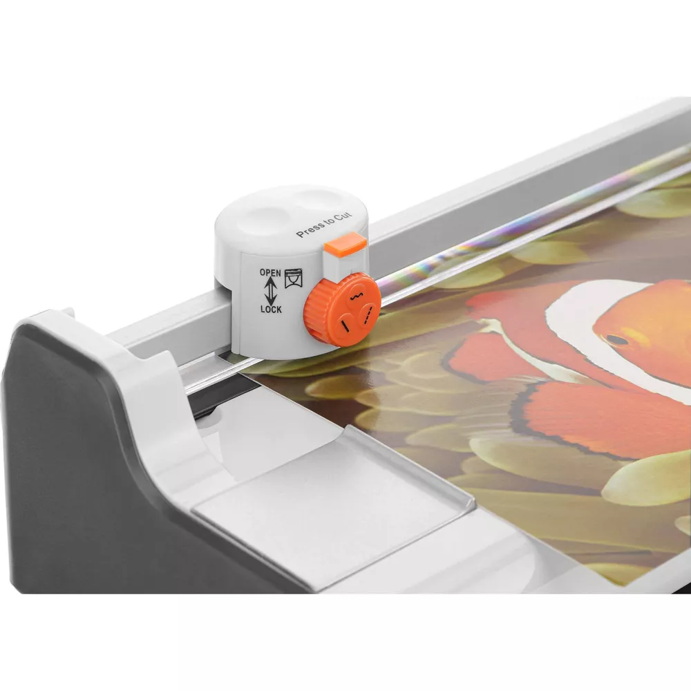 Nahaufnahme einer Papierschneidemaschine mit einem bunten Clownfisch-Motiv auf der Schneideunterlage.
