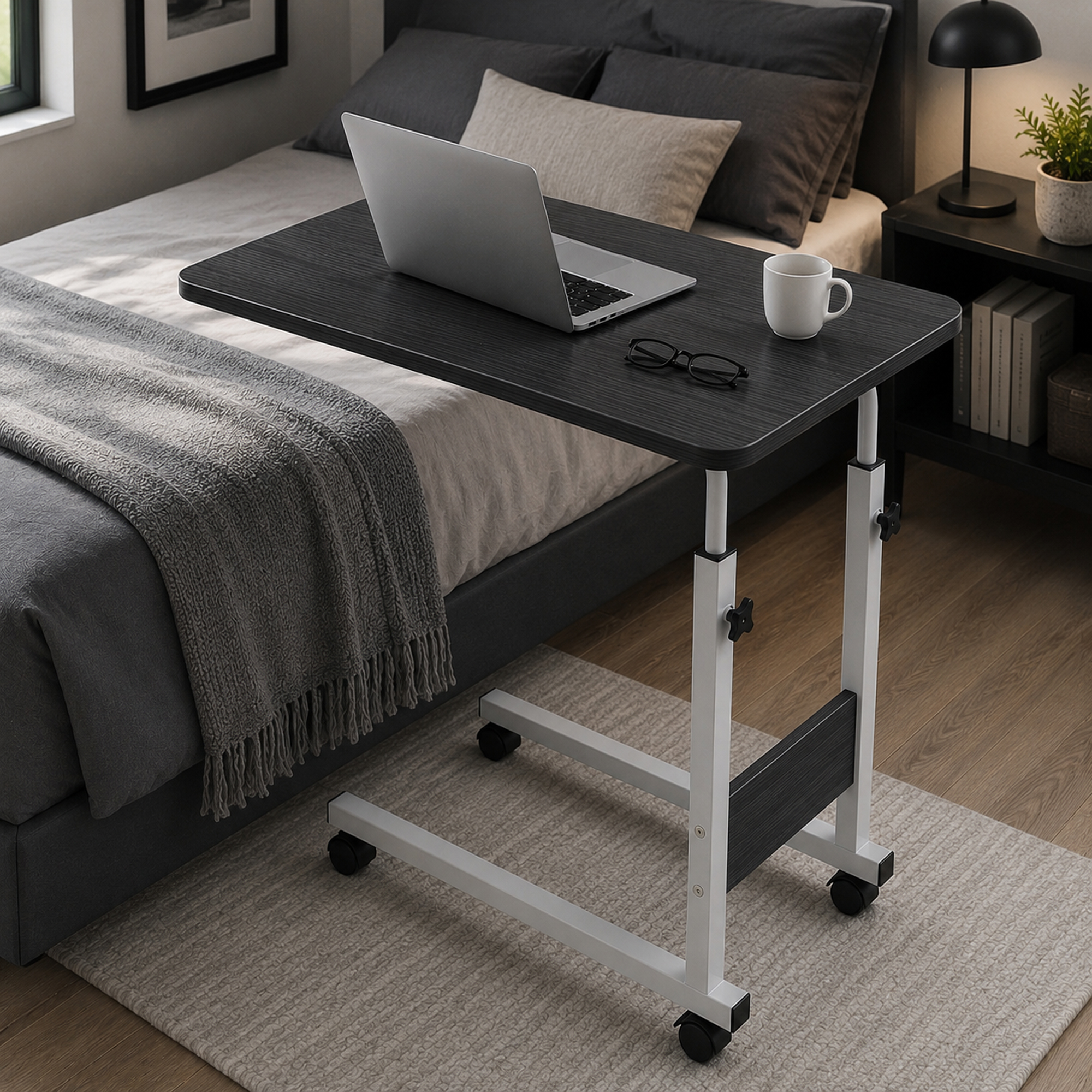 Una mesa de cama móvil con portátil, taza y gafas se encuentra en un dormitorio acogedor.